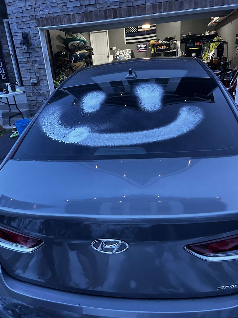 Blue Hyundai sedan with frost-covered windshield displaying a smiling face made from melted frost patterns